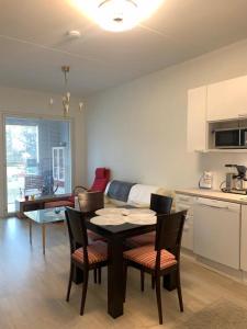 a kitchen and living room with a table and chairs at Modern Apartment nearby Airport in Vantaa