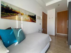 Un dormitorio con una cama blanca y una pintura en la pared en Studio City Center - Aloha Sevilla, en Sevilla
