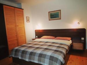 ein Schlafzimmer mit einem Bett mit einer karierten Decke in der Unterkunft apartments BS in Truskawez