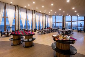 een restaurant met tafels en stoelen en grote ramen bij Hotel Palacio de Sal in Colchani