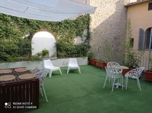 a patio with chairs and tables and a wall with ivy at B&B Palazzo Bianchi in Parma