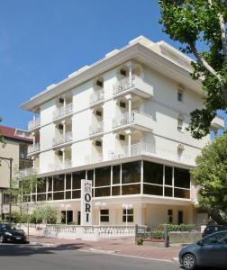 um edifício branco com varandas numa rua em Hotel Ori em Cesenatico