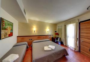 1 dormitorio con 2 camas y toallas. en Hotel Bed&Business en San Giovanni Teatino