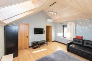 a living room with a black couch and a tv at Villa crocus in Lviv