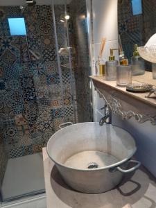 y baño con ducha con bañera grande de metal. en Le petit atelier, en Bormes-les-Mimosas