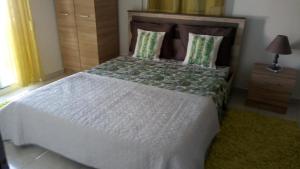 a bedroom with a bed with a white comforter at Gemani Apartments Rhodes city in Rhodes Town