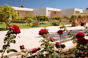 a house with red roses in front of a building at Hotel Rural Xereca in Puig D’en Valls