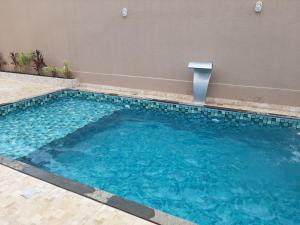 a swimming pool with blue water in a building at ESPAÇO FONDER in Caldas Novas