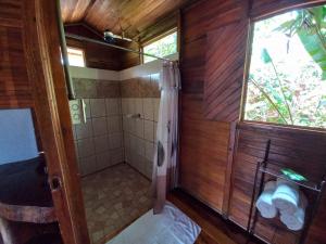La salle de bains en bois est pourvue d'une douche et d'une fenêtre. dans l'établissement Cabañas Los Laguitos Rio Celeste, à El Achiote
