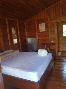 a bedroom with a bed in a wooden room at Cabañas Los Laguitos Rio Celeste in El Achiote