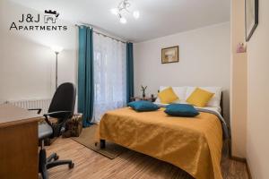 a bedroom with a bed with a desk and a chair at J&J Apartments, Szeroka 25 Apartament 13 in Toruń
