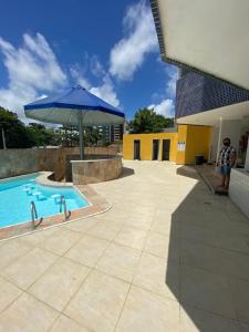 a large blue umbrella sitting next to a swimming pool at Flat - Victory Intermares in Cabedelo +4 photos