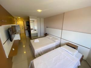 a hotel room with two beds and a television at Flat - Victory Intermares in Cabedelo