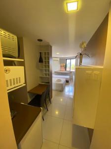 a kitchen with a sink and a table and a refrigerator at Flat - Victory Intermares in Cabedelo