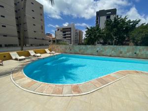 a large blue swimming pool in a city at Flat - Victory Intermares in Cabedelo