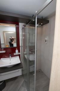 a person taking a picture of a bathroom with a shower at Landhotel Zum Hasen Hein in Hamminkeln