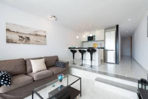 a living room with a couch and a kitchen at PARADISE VIEW APARTMENT MASPALOMAS in Maspalomas