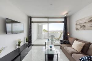 a living room with a couch and a glass table at PARADISE VIEW APARTMENT MASPALOMAS in Maspalomas