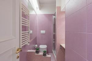 różowa łazienka z toaletą i różowymi kafelkami w obiekcie iFlat Via del Corso Elegant Apartment w Rzymie