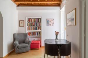 salon ze stołem, krzesłem i półką na książki w obiekcie iFlat Via del Corso Elegant Apartment w Rzymie