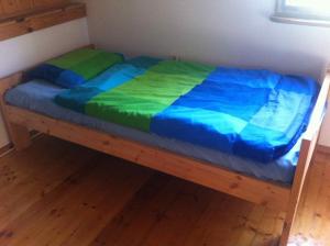 ein Bett mit einer blauen und grünen Bettdecke in einem Zimmer in der Unterkunft Bea Hive in Ostrzyce