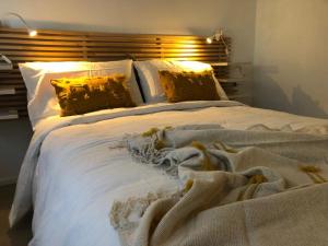 a large white bed with a blanket on it at Vivapartments MilanoSanSiro in Milan