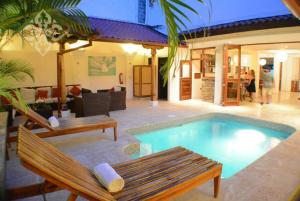 una piscina con 2 bancos y una casa en Hotel Alcazar en San Juan del Sur