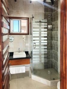 a bathroom with a glass shower and a sink at La Bocana de Quiximies Hotel in Cojimíes