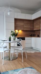 a kitchen with a white table and chairs at Au 53, sous le chartil in Reims