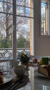a table with plates of food in front of a window at Au 53, sous le chartil in Reims
