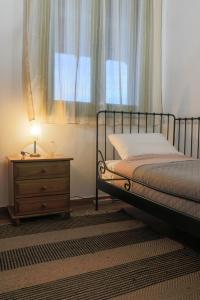 ein Schlafzimmer mit einem Bett, einer Kommode und einem Fenster in der Unterkunft Country Home Giannaras in Piána