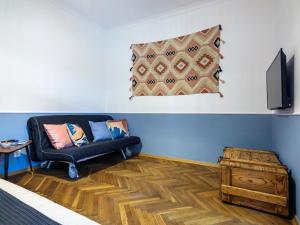 a living room with a black couch and a television at Silent blue apartment / Kochanowskigo St in Krakow