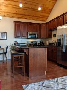 a kitchen with wooden cabinets and a stainless steel refrigerator at Carriage House Inn in Downieville