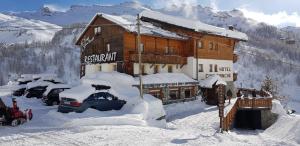 un edificio cubierto de nieve con coches aparcados fuera en Hotel Cime Bianche, en Breuil-Cervinia