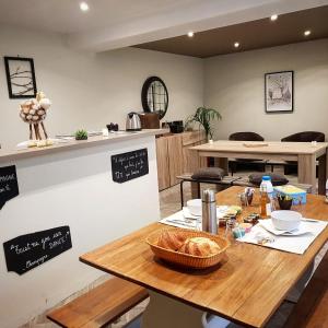 uma cozinha com uma mesa com um cesto de pão em Chambres privées à Hautvillers, berceau du champagne avec salle de bain et toilettes incluses em Hautvillers