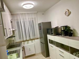 małą kuchnię z lodówką i oknem w obiekcie Big Und Nice 3 Bedrooms w Hanowerze