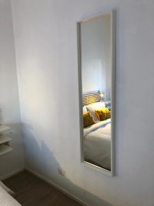a mirror on a white wall in a bedroom at Vivapartments MilanoSanSiro in Milan