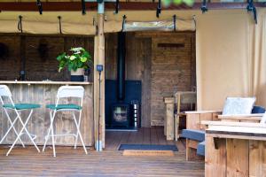 a patio with two chairs and a wood stove at Finest Retreats - Rusty Lane, Safari Lodge in Seend
