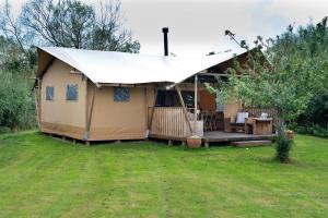 a tent with a porch in a yard at Finest Retreats - Rusty Lane, Safari Lodge in Seend