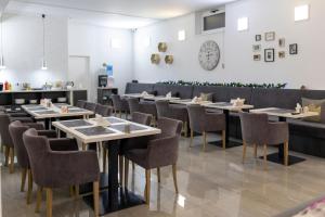 eine Reihe von Tischen und Stühlen in einem Restaurant in der Unterkunft Garni Hotel 11tica DM in Novi Sad
