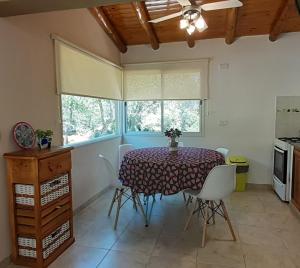 ein Esszimmer mit einem Tisch und einem Fenster in der Unterkunft COSTA COM Cabañas in Merlo