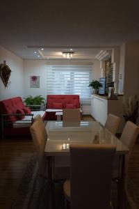 sala de estar con mesa y sofá rojo en Apartman Volijak, en Jajce