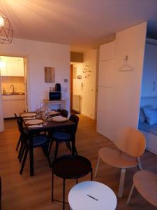 a dining room with a table and chairs and a kitchen at relax @the beach in De Haan