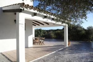 Una pérgola blanca con una mesa de picnic debajo. en La Quinta de María Luisa, en Zahora