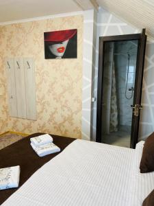 un dormitorio con una cama y una pintura de una mujer en Під явором NEW en Drogomirchany