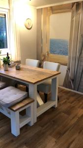 a dining room table with chairs and a clock on the wall at Sunnychalet in Beekbergen