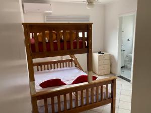 a bedroom with two bunk beds with red pillows at Cobertura Guarujá Apto com Jacuzzi e Churrasqueira in Guarujá