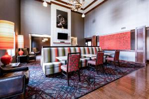 a lobby with a waiting room with tables and chairs at Black Gold Suites in Tioga