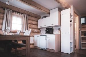 a kitchen with white cabinets and a table and a counter at Hiska Ulala in Dob