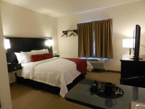 a hotel room with a large bed and a table at Black Gold Suites in Tioga